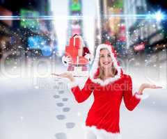 Composite image of festive blonde holding hands out