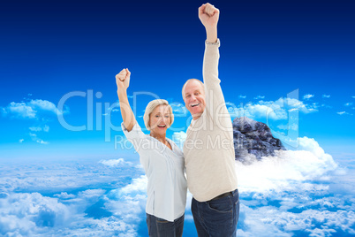 Composite image of happy mature couple cheering at camera