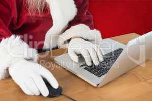 Composite image of santa surfs on the internet