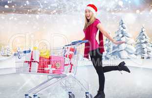 Composite image of festive blonde pushing trolley full of gifts