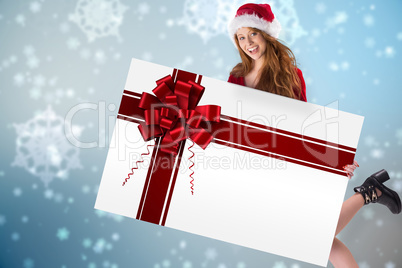 Festive redhead smiling at camera holding poster