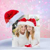 Composite image of festive mother and daughter smiling at camera