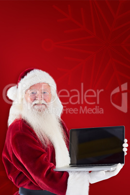 Composite image of santa claus presents a laptop