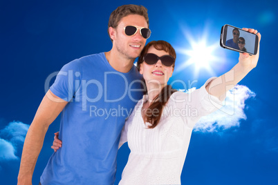 Composite image of couple using camera for picture