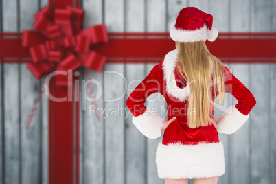 Composite image of festive blonde standing rear view