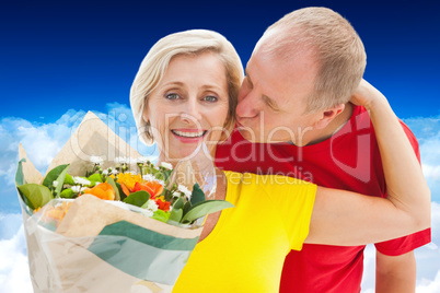 Composite image of mature man kissing his partner holding flower