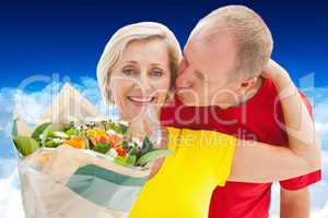 Composite image of mature man kissing his partner holding flower