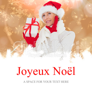 Composite image of festive woman holding gift