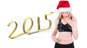 Composite image of fit festive young blonde looking at measuring