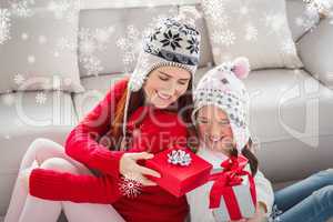 Composite image of mother and daughter exchanging gifts at chris
