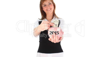 Composite image of woman putting money in a piggy bank