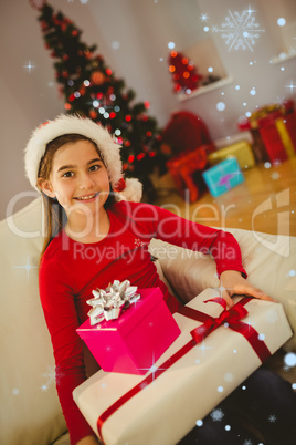 Composite image of festive little girl smiling at camera with gifts