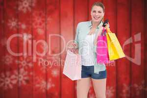 Composite image of pretty blonde smiling at camera holding shopp