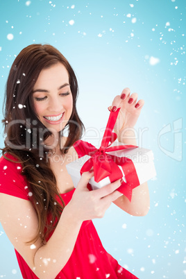 Composite image of happy brunette sitting and opening gift