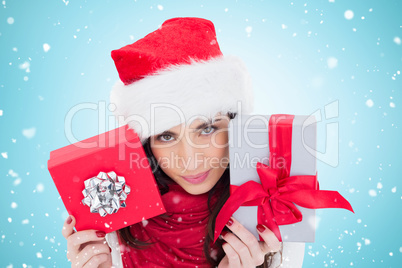 Composite image of cheerful brunette holding christmas gifts
