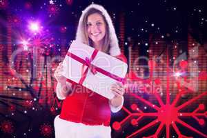 Composite image of pretty santa girl holding gift