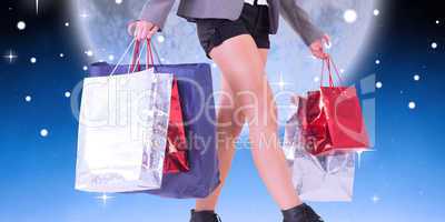 Composite image of lower half of woman with shopping bags