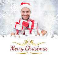 Composite image of festive man holding christmas gifts