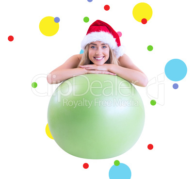 Composite image of festive fit blonde posing with exercise ball