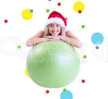 Composite image of festive fit blonde posing with exercise ball
