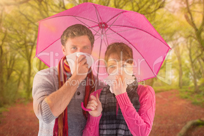 Composite image of couple standing underneath an umbrella