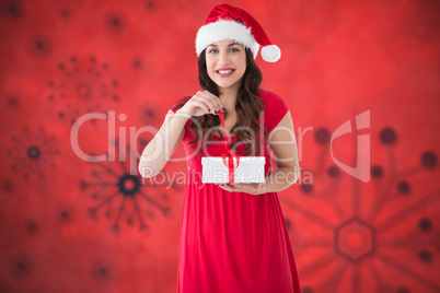 Composite image of festive brunette opening gift