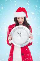 Composite image of excited brunette holding a clock