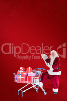 Composite image of santa pushes a shopping cart while reading