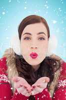 Composite image of festive brunette with lipstick blowing a kiss