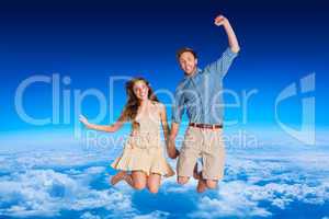 Composite image of cheerful young couple jumping