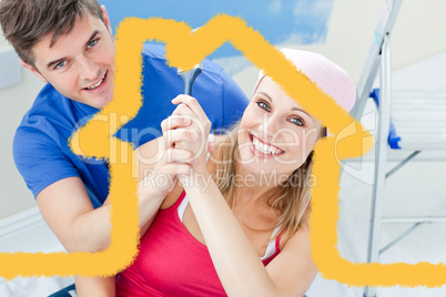 Composite image of hugging couple having fun while painting a ro