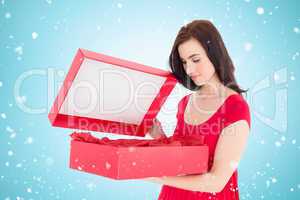 Composite image of stylish brunette in red dress opening gift