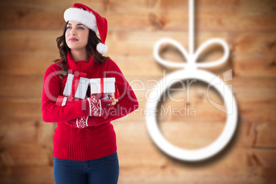 Composite image of thoughtful brunette holding many gifts