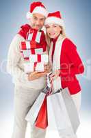 Composite image of happy festive couple with gifts and bags