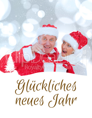 Composite image of festive mature couple holding gift