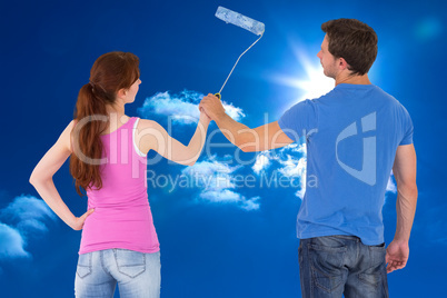 Composite image of couple painting a wall together