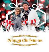 Composite image of festive mature couple holding christmas gifts