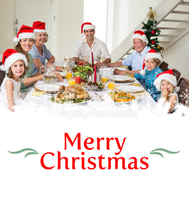 Composite image of happy family in santa hats having christmas m