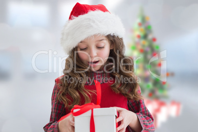 Composite image of cute girl looking at gift