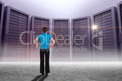 Composite image of young businesswoman standing with hands on hi