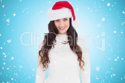 Composite image of beautiful brunette in santa hat smiling at ca