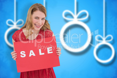 Composite image of smiling blonde showing a red sale poster