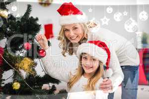 Composite image of festive mother and daughter decorating christ