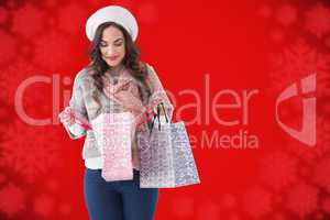 Composite image of brunette in winter clothes looking in shoppin