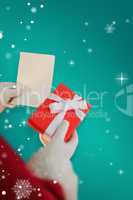 Composite image of father christmas holding a gift