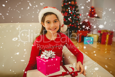 Composite image of festive little girl smiling at camera with gi