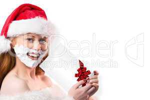 Composite image of festive redhead in foam beard holding gift