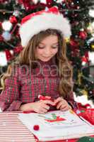 Composite image of festive little girl drawing pictures