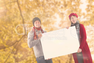 Composite image of couple holding a large sign