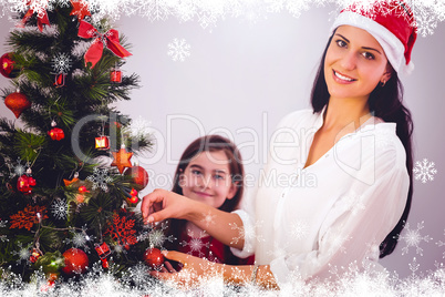 Composite image of mother and daughter hanging christmas decorat